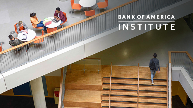 Group of students studying on open plan mezzanine with student walking up a staircase.
